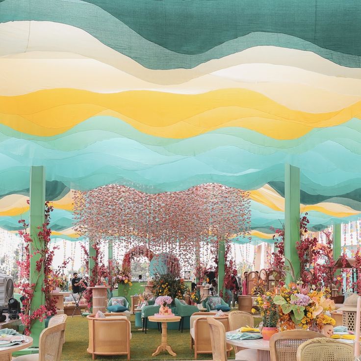 Pastel mehendi lounge with a wavy layered backdrop and a hanging floral cloud by RAW Group
